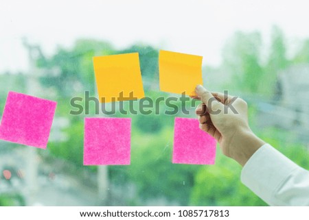 Closeup hand of creative businessman holding on sticky paper at office