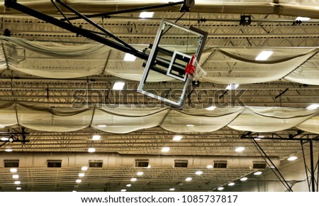 Basketball net raised and hanging sideways with "DO NOT HANG" written on bottom of backboard.