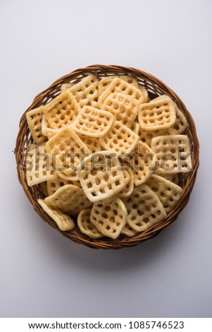 Square shape checkered Fryums Papad is a crunchy Snack Pellets served in a bowl
