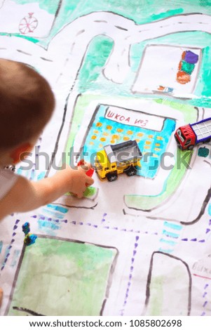 the child plays on the road map with cars