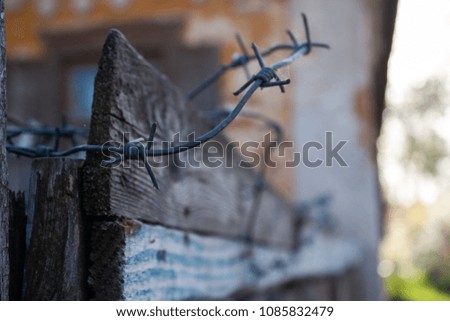 An old wooden fence. Corded wire on the fence.