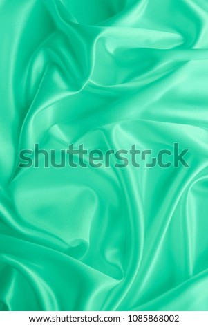 Beautiful smooth elegant wavy seafoam green satin silk luxury cloth fabric texture, abstract background design. Card or banner.