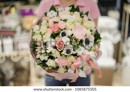 Girl in white shirt holding in her hands a beautiful big bouquet of rose colour and white tender flowers