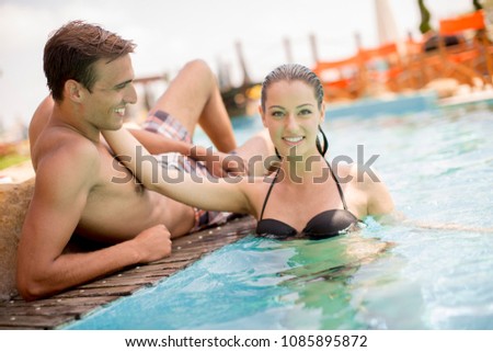 Portrait of a smiling young couple in a swimming pool