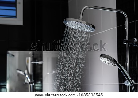 Close up of Water flowing from shower in the bathroom Royalty-Free Stock Photo #1085898545