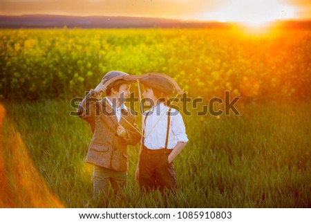 Portrait of children playing with bow and arrows, archery shoots a bow at the target on sunset Royalty-Free Stock Photo #1085910803