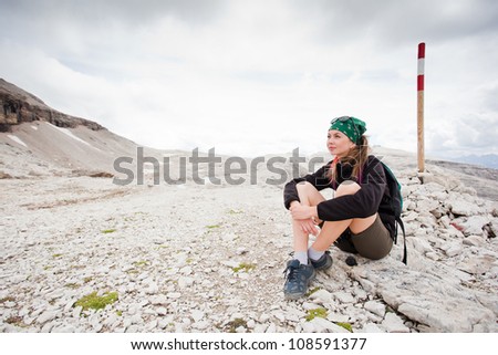 cute girl hiking in the alps pointing at a beautiful scenery