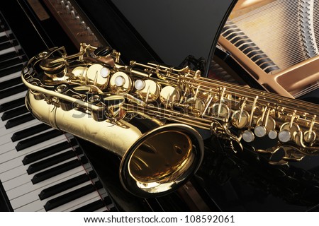 Alto saxophone on grand piano Royalty-Free Stock Photo #108592061