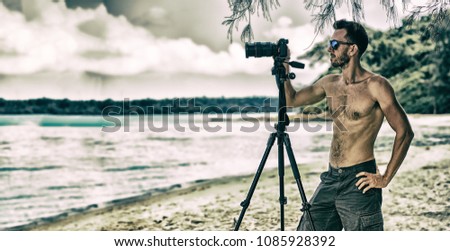 muscular man taking photo on a tropical beach