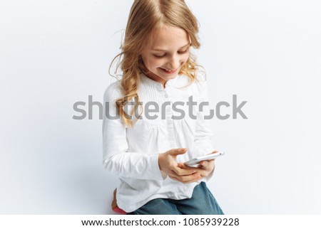 Beautiful teen girl looking at the phone, talking on video, photo Studio