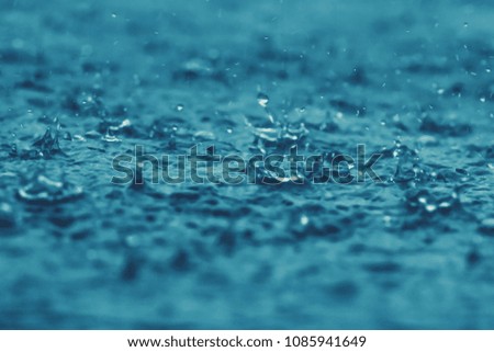 blue color tone of rain water drop falling to the floor in rainy season