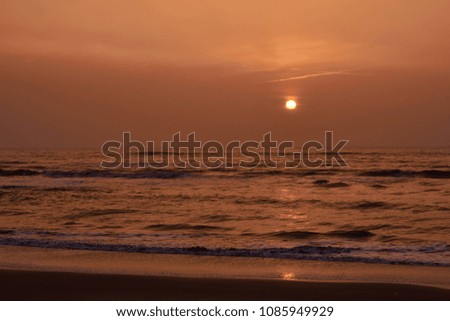 Impressive warm sunset and reflection of the sun at the north sea, Netherlands