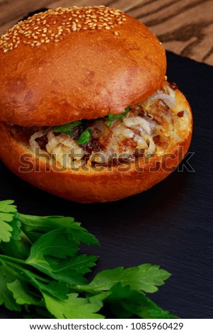 Homemade hamburger with fried onion on a wooden table