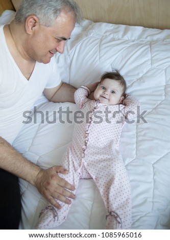 Mid-aged father and a cute happy little baby girl at home. Family on summer day