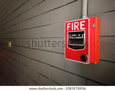 Red Fire Alarm on gray brick wall in building