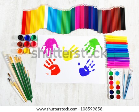 Painting tools set and multicolor child hand prints. Creativity concept. Top view.