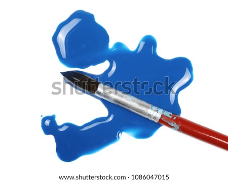 Spilled blue watercolor with paintbrush isolated on white background, top view