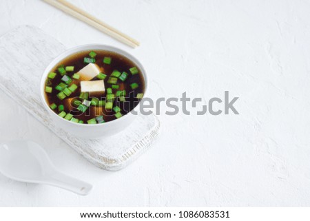 Japanese miso soup in ceramic bowl on white background, copy space. Asian miso soup with tofu.