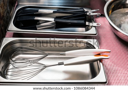 Metal and plastic kitchen tools lie in tray