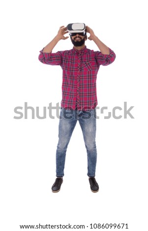 Full-length shot of a funny young man wearing VR glasses and he is looking up, isolated on white background.