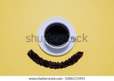 Coffee cup and saucer making a minion smiling face on a bright yellow background