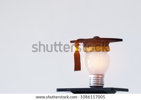 Education or Graduate study Creative concept: Hands holding light bulb with Graduated hat on gray background. Ideas with innovation creativity for Educational successs studies world. back to School Royalty-Free Stock Photo #1086117005