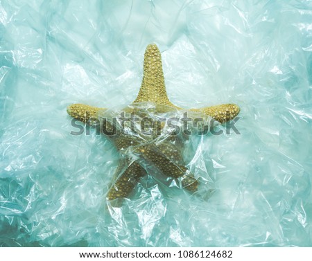 Starfish aquatic animal trapped in plastic,concept ocean waste contamination pollution water toxic residues in the sea.Save the planet,save the ocean, Royalty-Free Stock Photo #1086124682