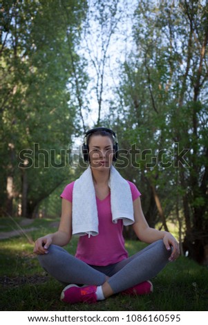 Young woman outdoor meditation, listening to the music.