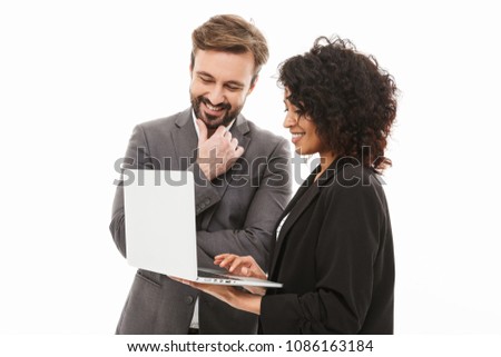 Portrait of a happy business couple looking at laptop computer isolated over white background