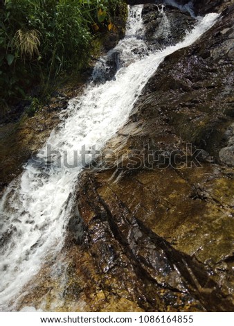 The water flowing from the waterfall ,the movement of the water .