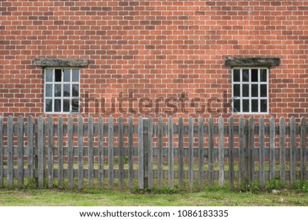 Abstract image of old brick house surrounded with wooden fence at countryside in rainy day.