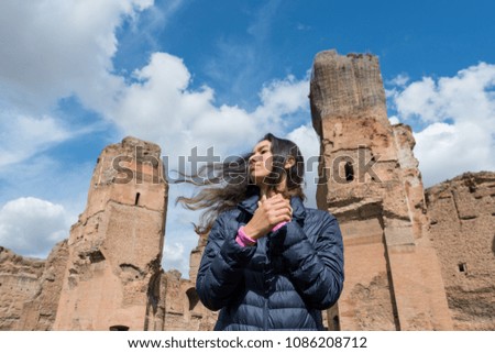 Horizontal picture of long and black hair girl posing in front of the ruins of Baths of Caracalla, important landmark located in Rome Italy