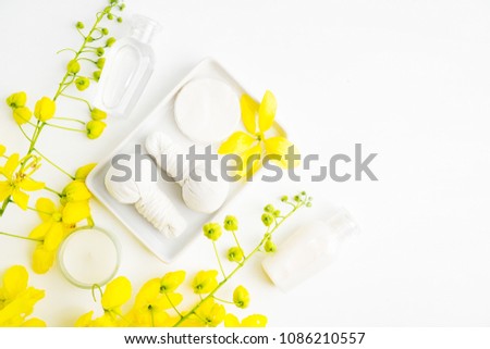 Bright spa background: candles and thai massage herbal bags with bottles and yellow flowers on white. Health, skin treatment concept Royalty-Free Stock Photo #1086210557