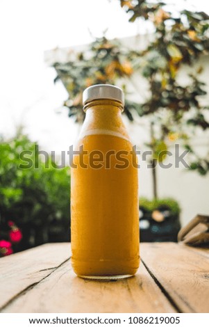 Bottled orange juice in a cute garden cafe