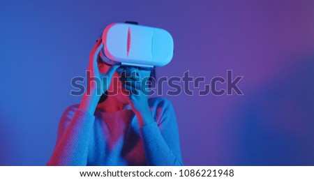 Woman watching with VR with red and blue light 