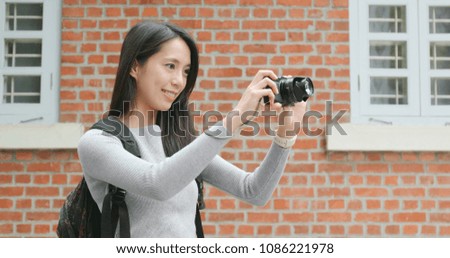 Young woman taking photo on digital camera 