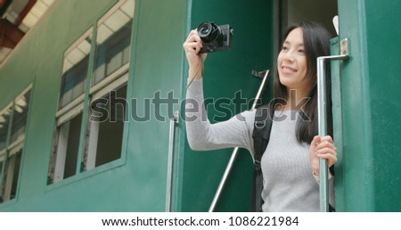 Woman taking photo on digital camera on train 