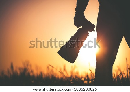 Safari Outdoor Photographer at Sunset. Silhouette of Men Keeping Digital Camera in Hand with Large Telephoto Lens For the Better Wildlife Closeups. Royalty-Free Stock Photo #1086230825