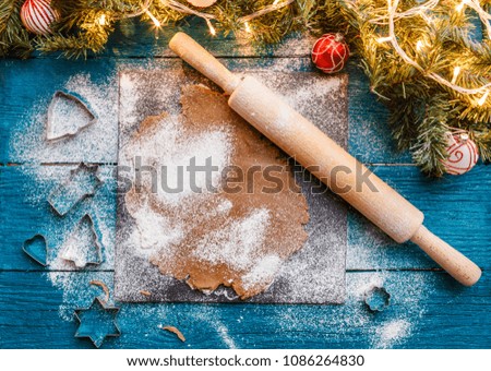 Photo of rolling pin, dough, spruce branches, garlands