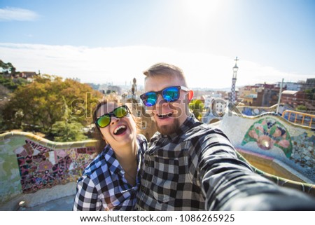 Travel couple happy making selfie portrait with smartphone in Park Guell, Barcelona, Spain. Beautiful young couple looking at camera taking photo with smart phone smiling in love Royalty-Free Stock Photo #1086265925