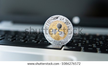 Silver gold ripple coin on a laptop keyboard closeup. Blockchain mining. Digital money and virtual cryptocurrency concept. Crypto currency investment. Digital money. Metal coins. Bussiness, commercial