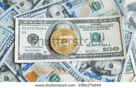 Golden Dash Cryptocurrency coin on a pile of US dollars, cash money and crypto currency concept. Virtual. Metal coins of Dash coin on banknotes of one hundred dollar. Exchange. Bussiness, commercial.