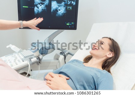 Woman at the gynecologist having ultrasonic examination as pregnancy test