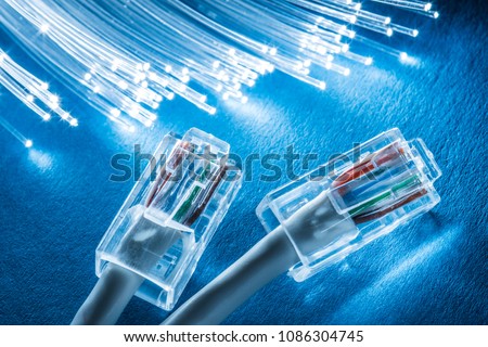 Network cables and optical fibers with lights in the ends at the background. Royalty-Free Stock Photo #1086304745