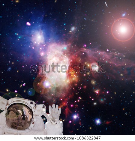 Astronaut against deep space. Galaxies and stars on backdrop. The elements of this image furnished by NASA.