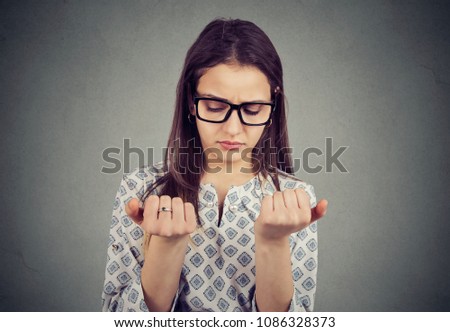 Perfectionist young woman looking at fingers nails obsessing about cleanliness