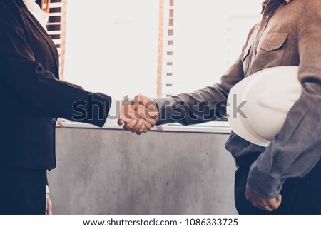 Asian Business people shaking hands and smiling their agreement to sign contract and finishing up a meeting