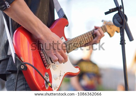 man playing electric guitar with nature light 