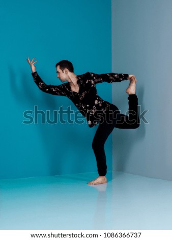 Modern ballet dancer in black shorts performing art dance element background