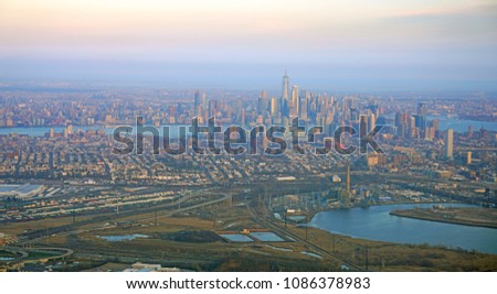 Aerial view of the Manhattan skyline in New York City seen from an airplane window at sunset